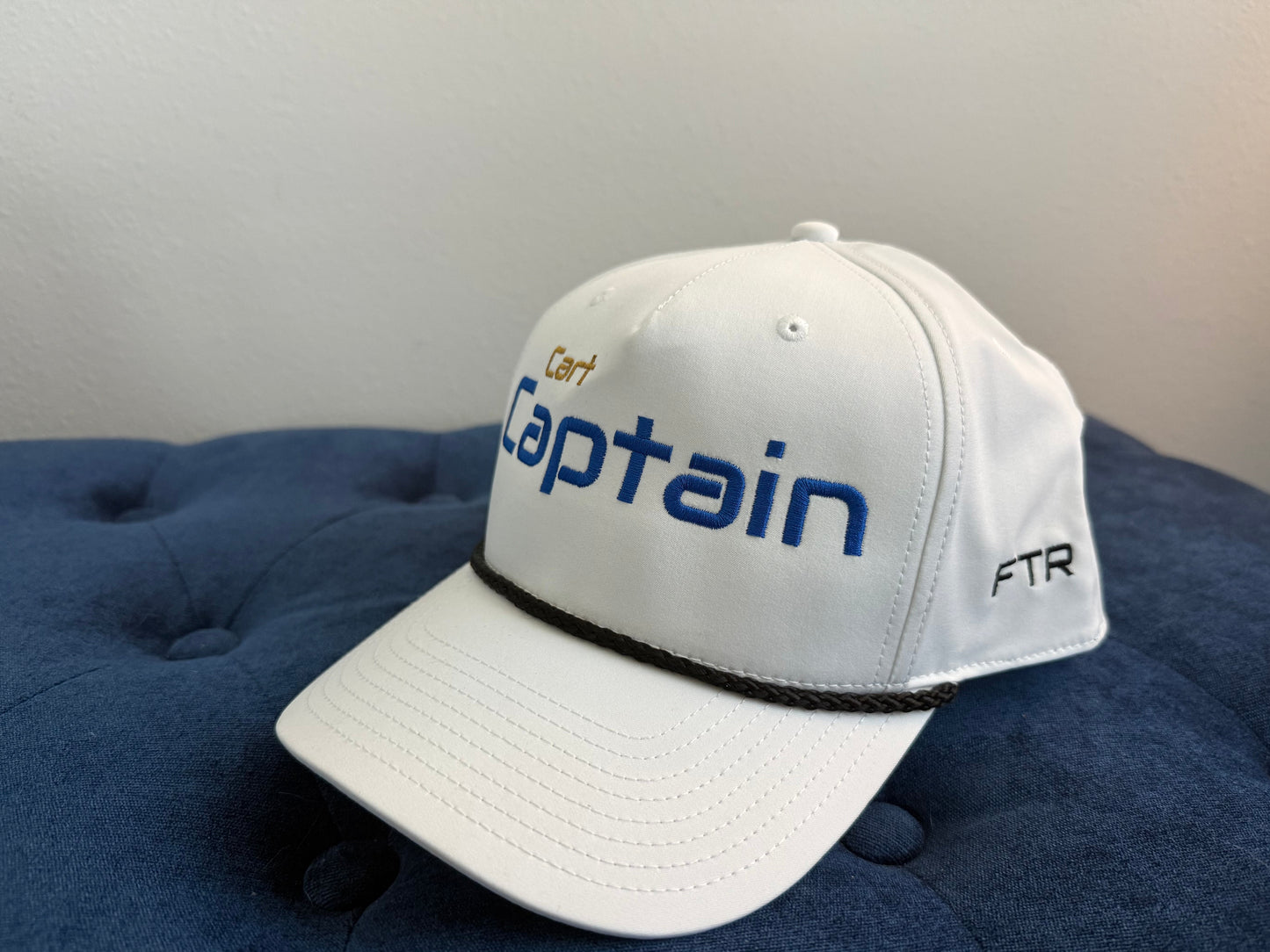White cap with 'Captain' and 'FTR' text on a blue cushion